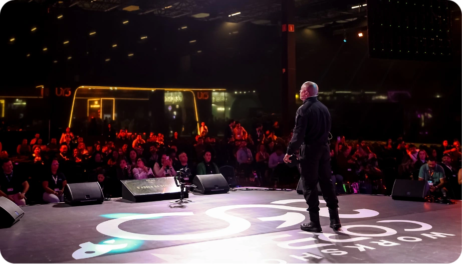 Palco escuro com feixe vermelho central representando uma palestra de impacto